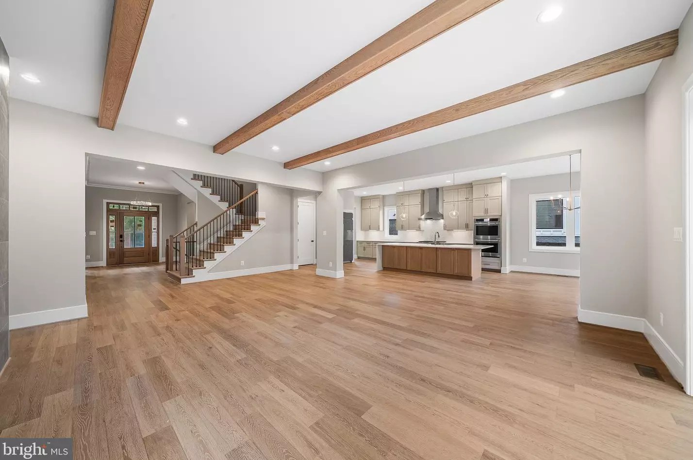 Great Room open to the kitchen beneath vaulted beamed ceilings