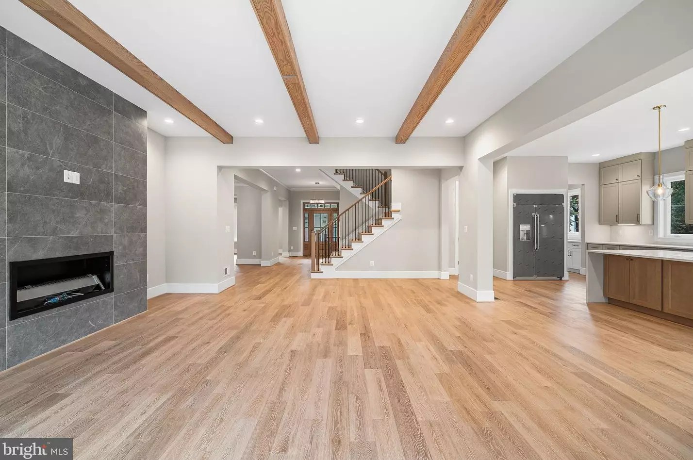 Great Room with natural wood beams and floor-to-ceiling tile gas fireplace