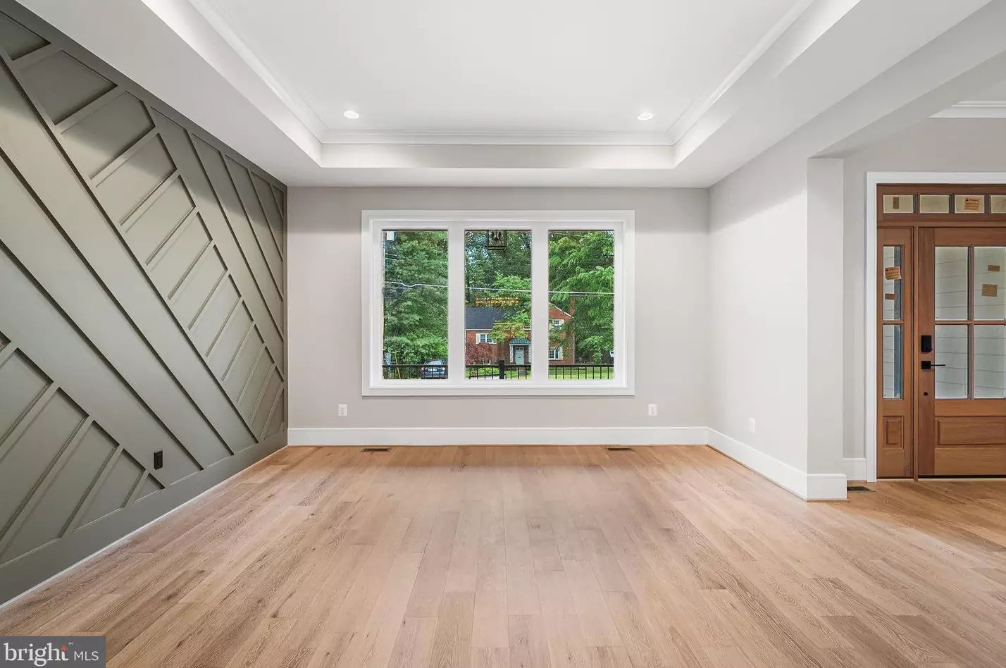 Formal living room with wood front door and large window
