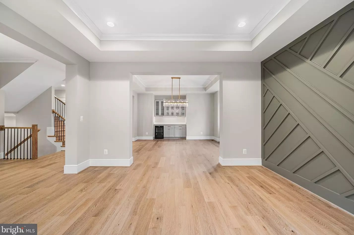 Formal living room with tray ceiling and paneled accent wall