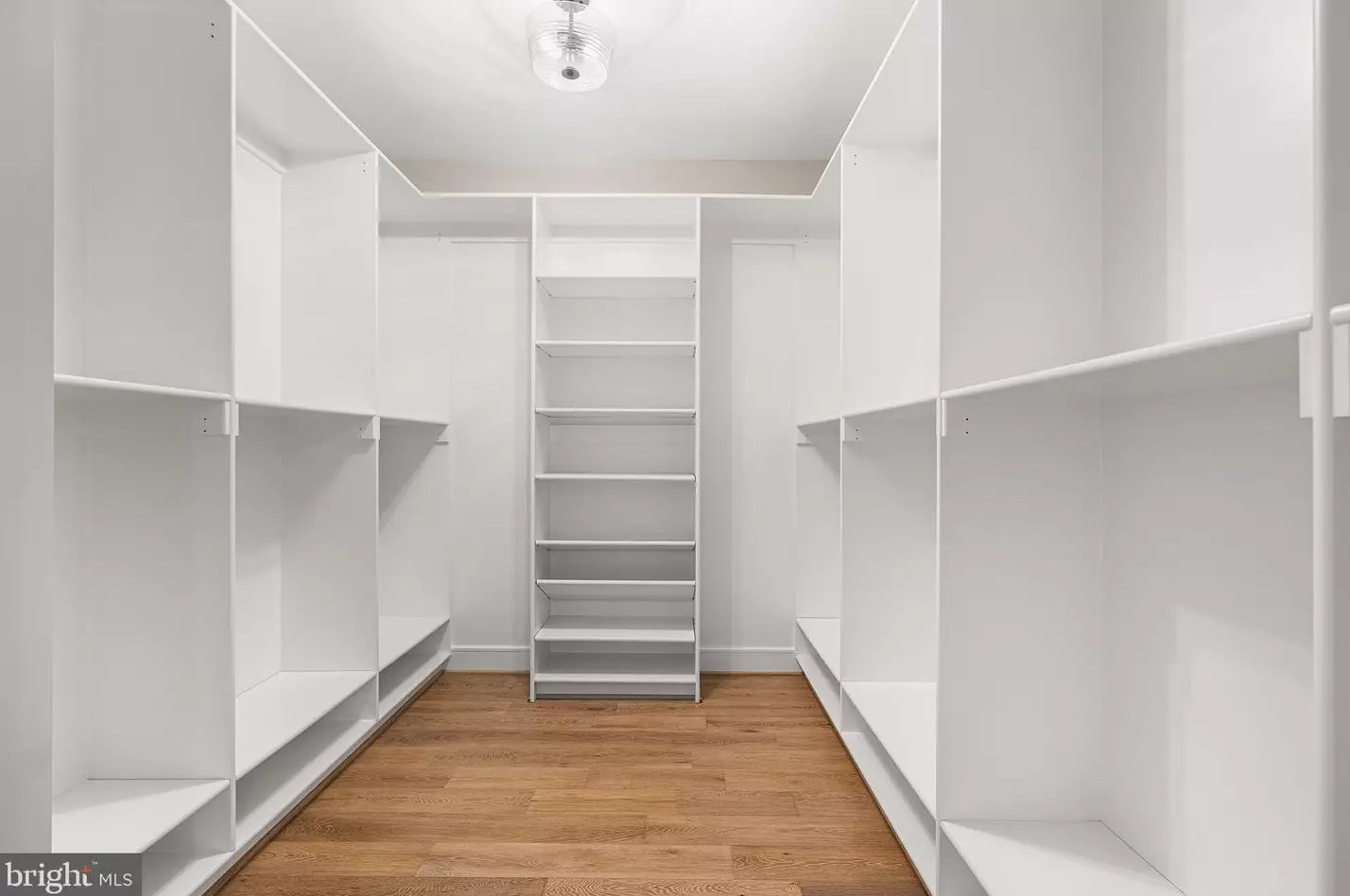 Primary walk-in closet with custom shelving and hanging systems